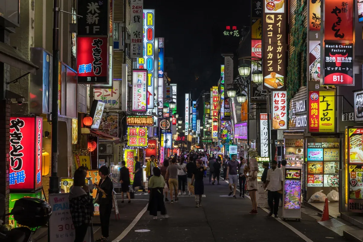 Lit street in Kabukicho Shinjuku where go-kart convoys ride in traffic in Tokyo, Japan